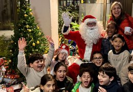 Alle Kinder freuen sich über den Weihnachtsmann und die schönen Geschenke.