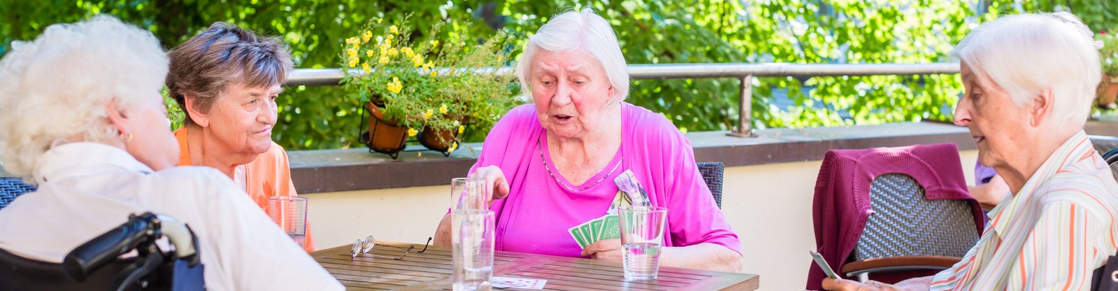 Seniorinnen, die auf der Terrasse Karten spielen