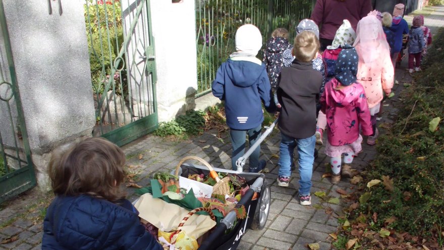 Die Kitakinder holen gemeinsam die Erntekörbchen aus der Bergholzer Kirche ab. 