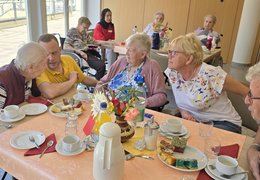 Bei Kaffee und Kuchen tauschen sich Bewohner*innen, Gäste und Team gemütlich aus