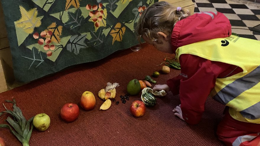 Die Kinder legen ihre Erntegaben an den Altar.